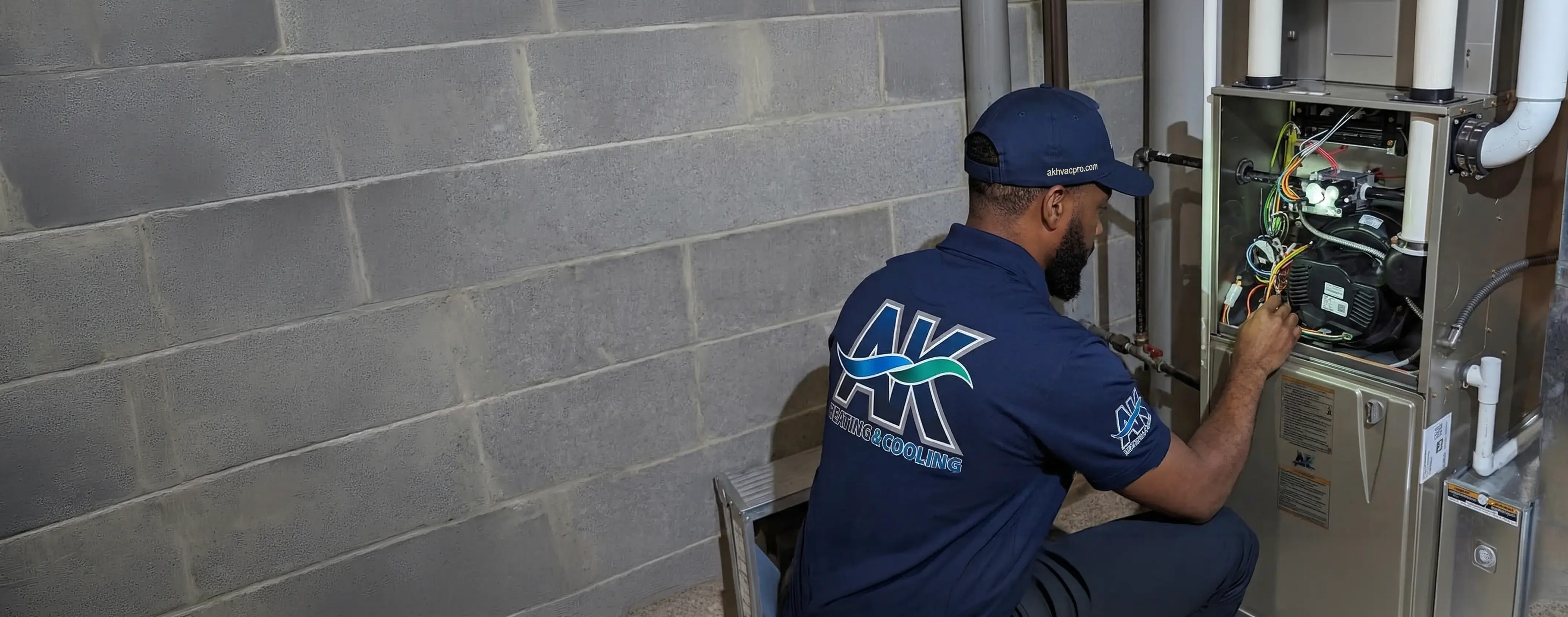AK Heating & Cooling technician servicing an HVAC system